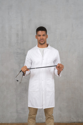 Médico varón sosteniendo un estetoscopio