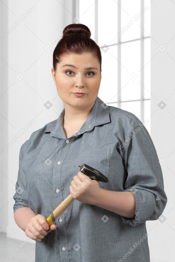 Frau, die einen hammer hält