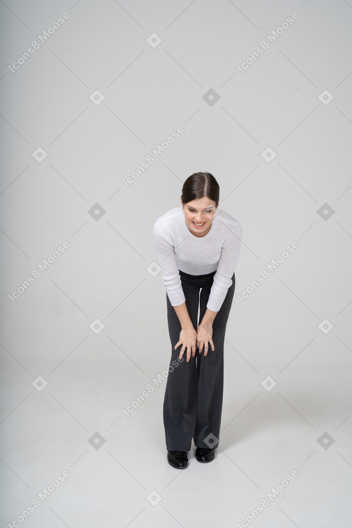Front view of a woman in suit bending down