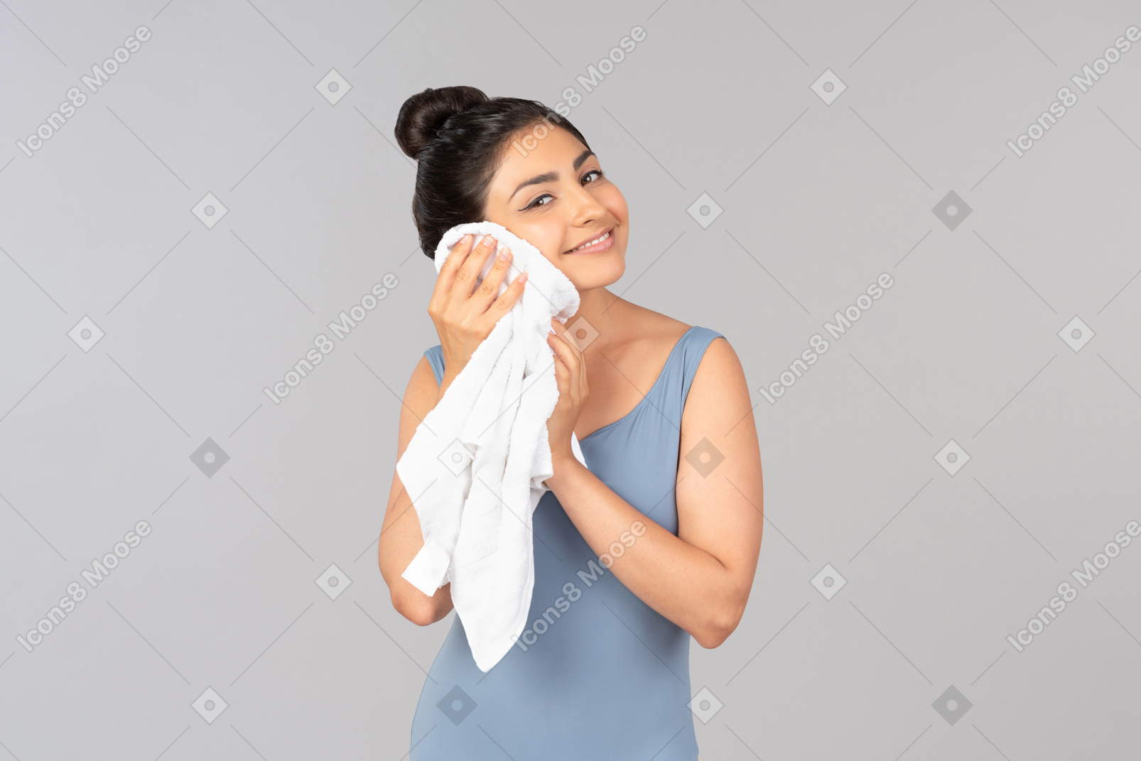 Smiling young indian woman wiping face with his towel
