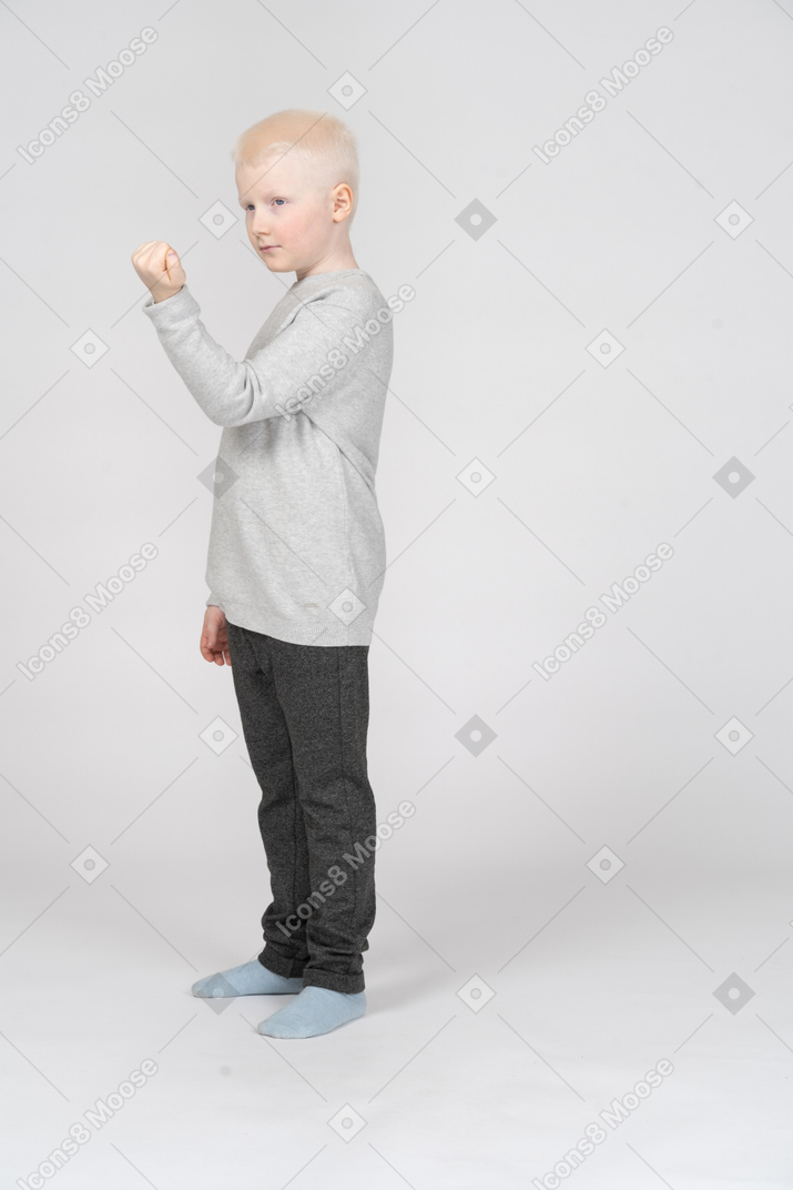 Side view of a boy showing clenched fist