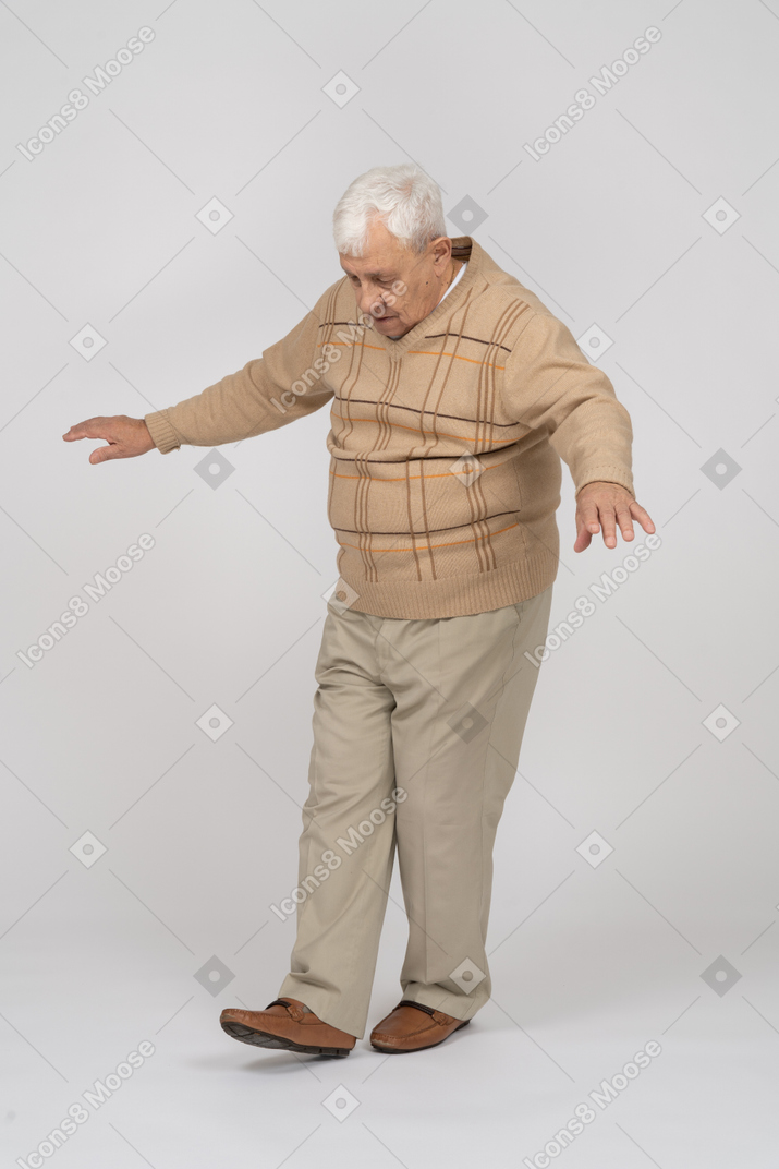 Front view of an old man in casual clothes walking forward