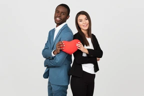 Beautiful interracial couple holding a toy heart together