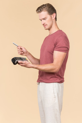 Young guy using a payment terminal