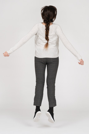 Unrecognizable brunette female jumping up back to camera