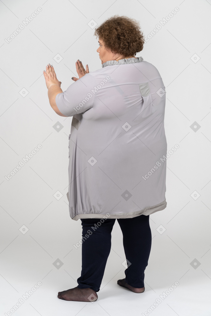 一个女人显示停止手势的后视图