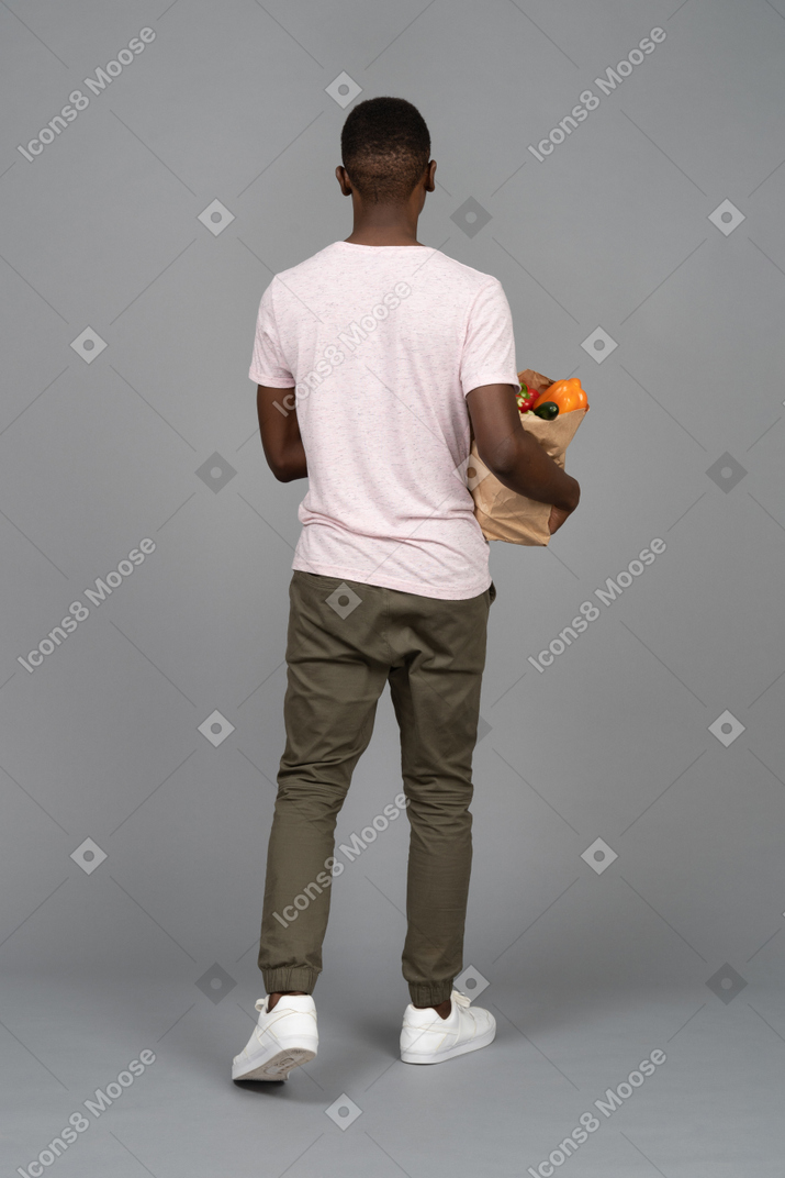 一个年轻人背着购物袋