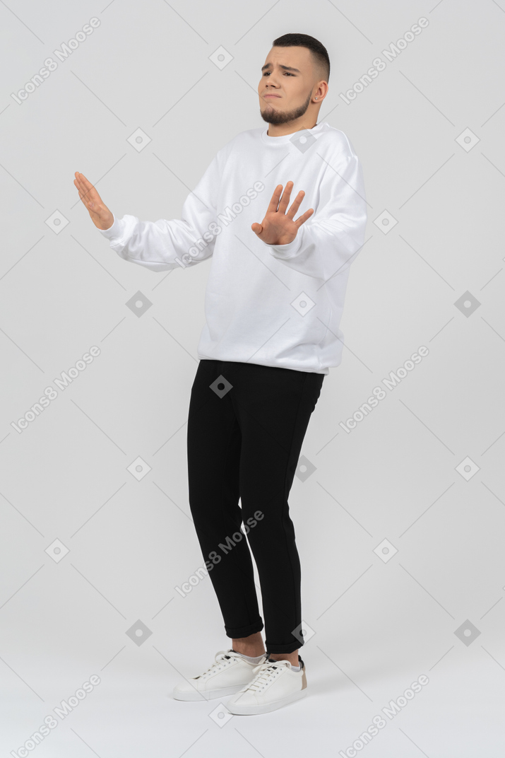 Worried young man raising his hands