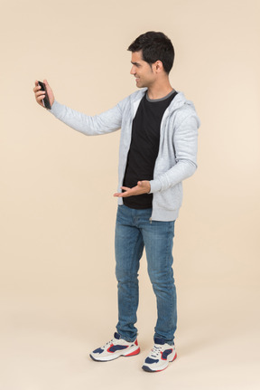 Young caucasian guy looking at smartphone