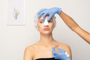 Nurse putting gauze on patient's nose