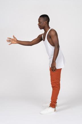 Side view of young man outstretching his hand and offering handshake