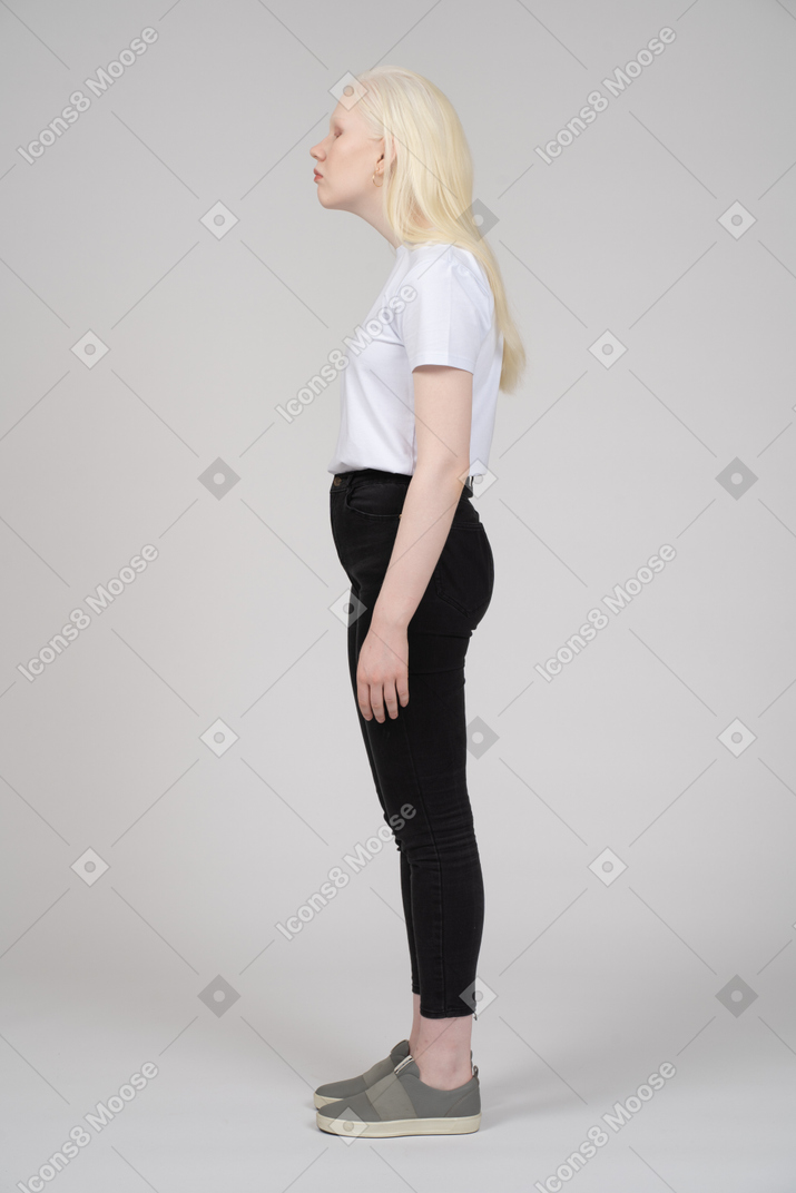 Vista lateral de uma adolescente com braços nas laterais