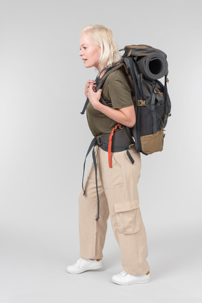 Mature female tourist carrying heavy backpack and kind of gasping