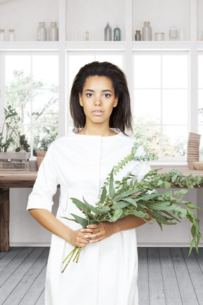 Une femme dans une robe blanche tenant un bouquet de fleurs