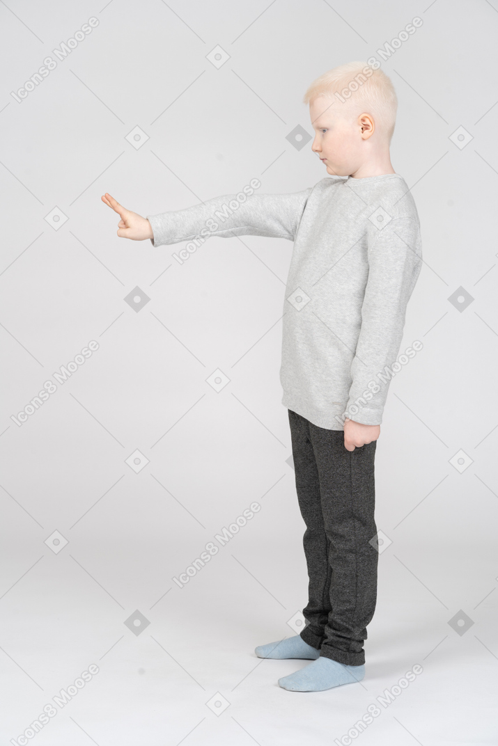 Side view of a boy making a peace sign