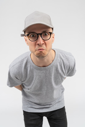 A man in a gray cap and gray t-shirt staring at the camera