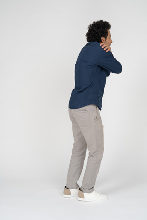 Side view of a man in casual clothes hugging himself