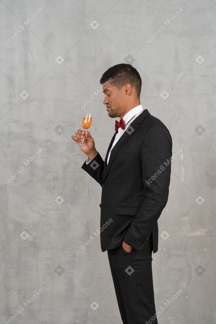 Side view of unimpressed man holding a champagne glass
