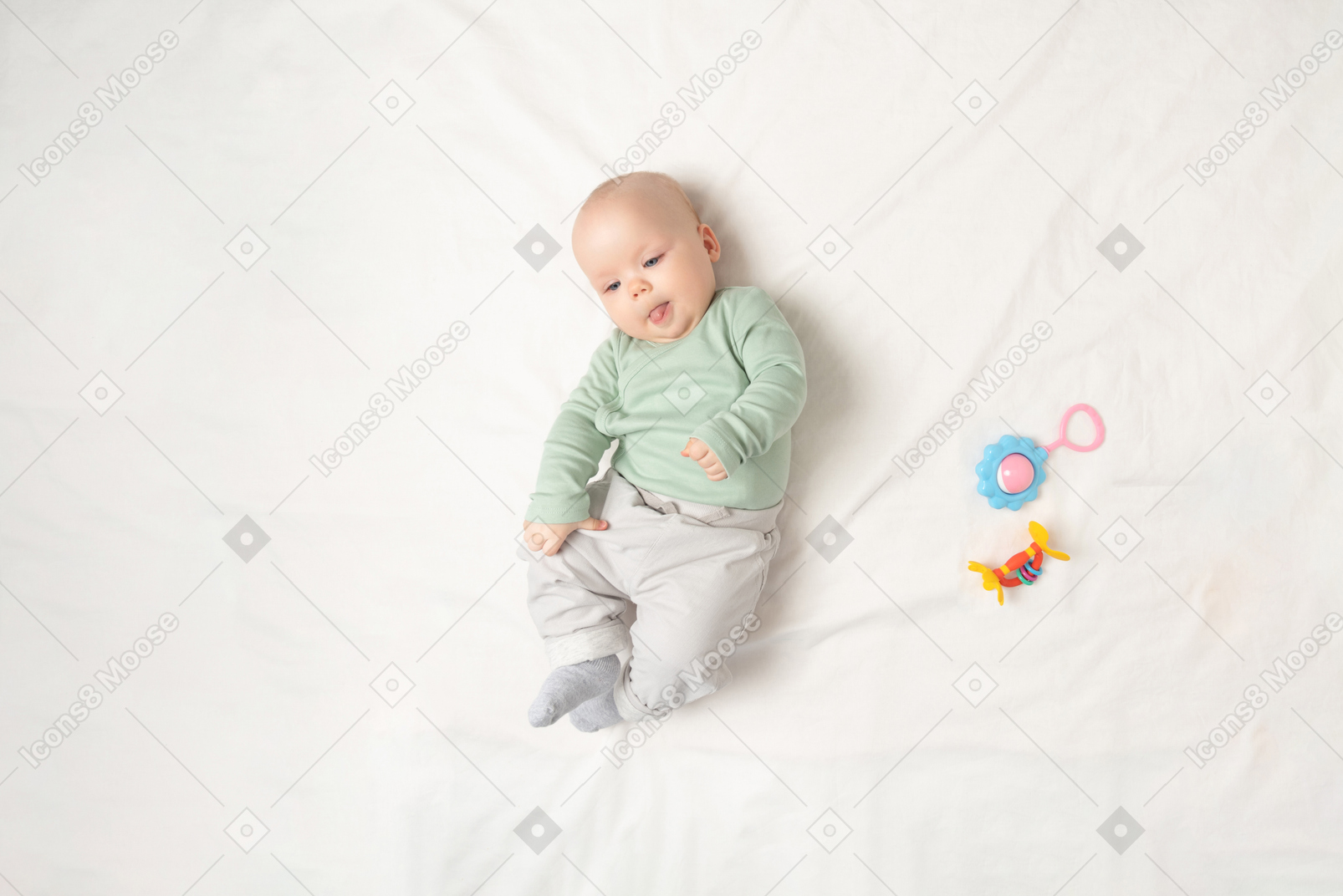Девочка лежит на спине возле игрушки