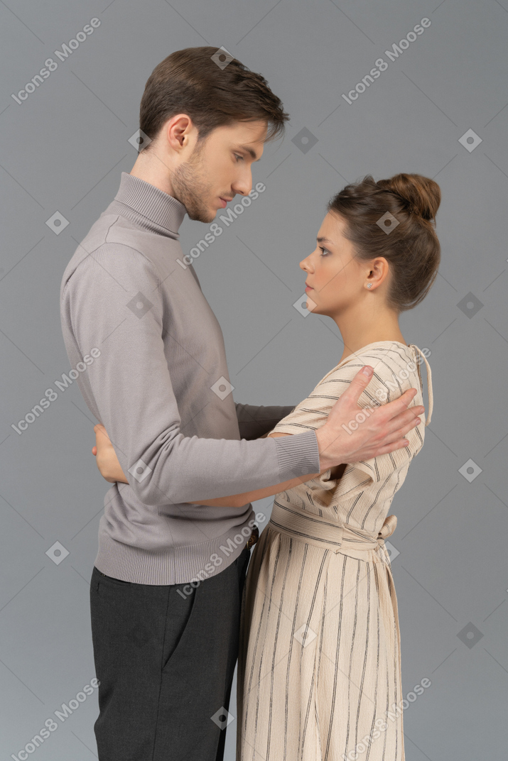 Jeune couple avec leurs bras l'un autour de l'autre