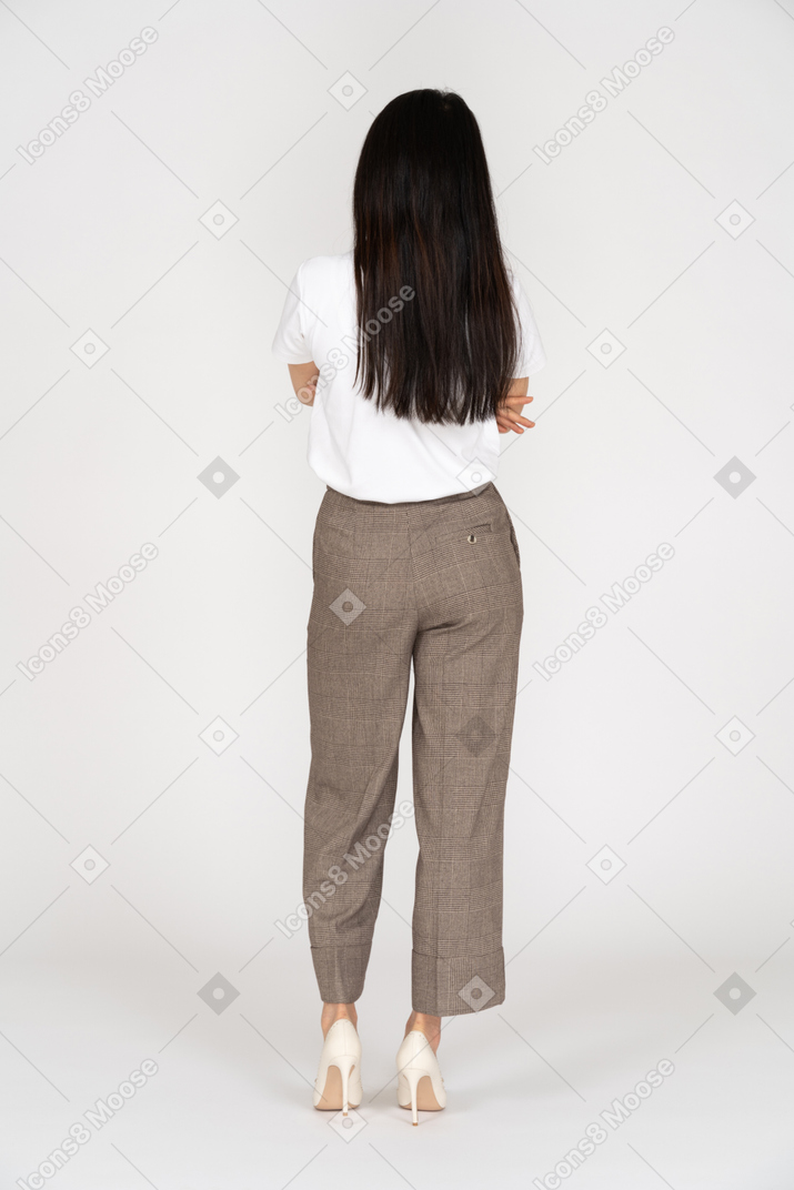 Back view of a young woman in breeches crossing hands