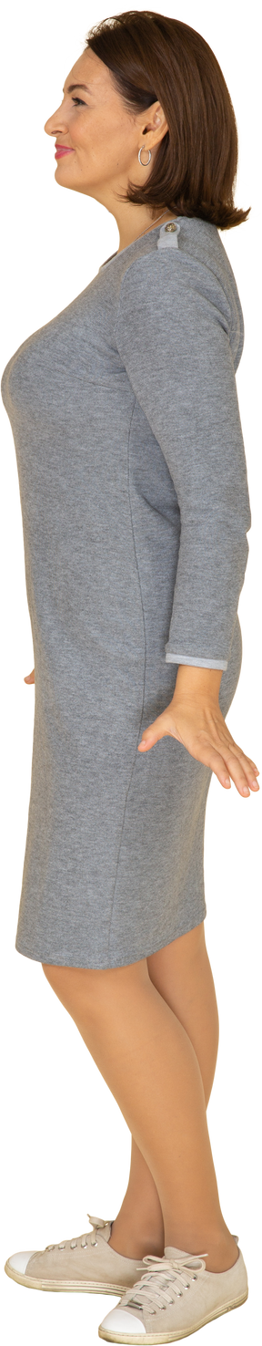 Vista laterale di una donna in abito grigio in posa