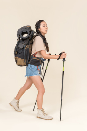 Donna escursionista a piedi con bastoncini da trekking