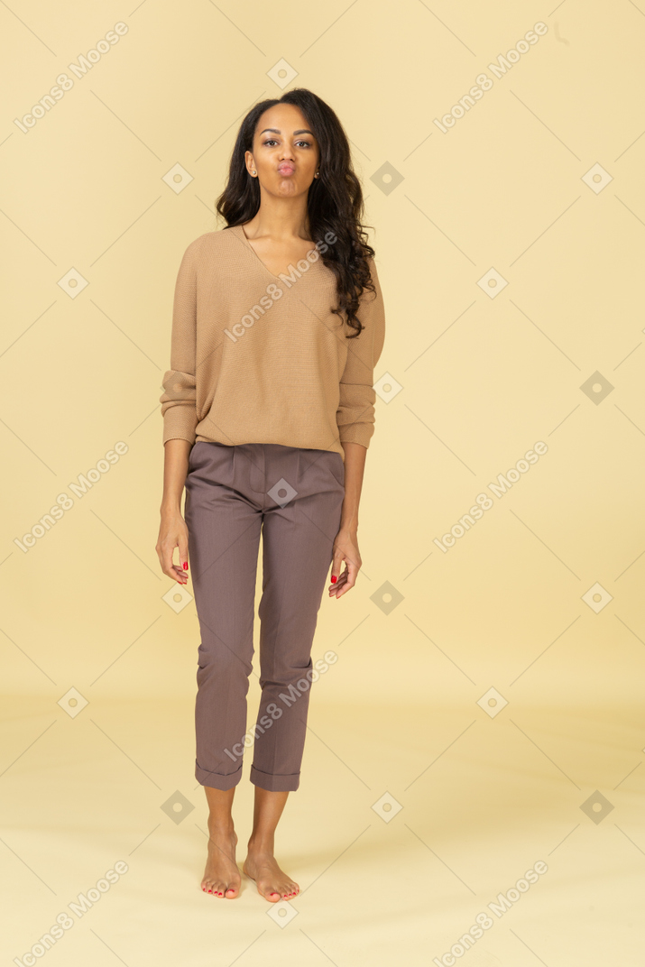 Front view of a young female in casual clothes pouting