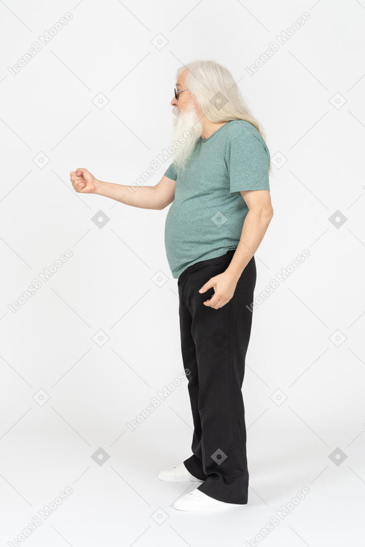 Side view of old man in sunglasses threatening with fist