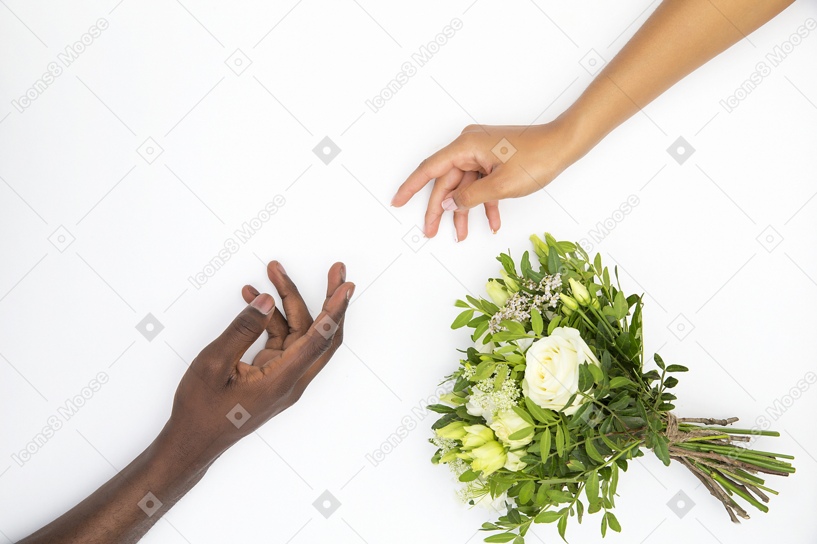 Mani nere maschili e bianche che quasi si toccano vicino al bouquet di fiori