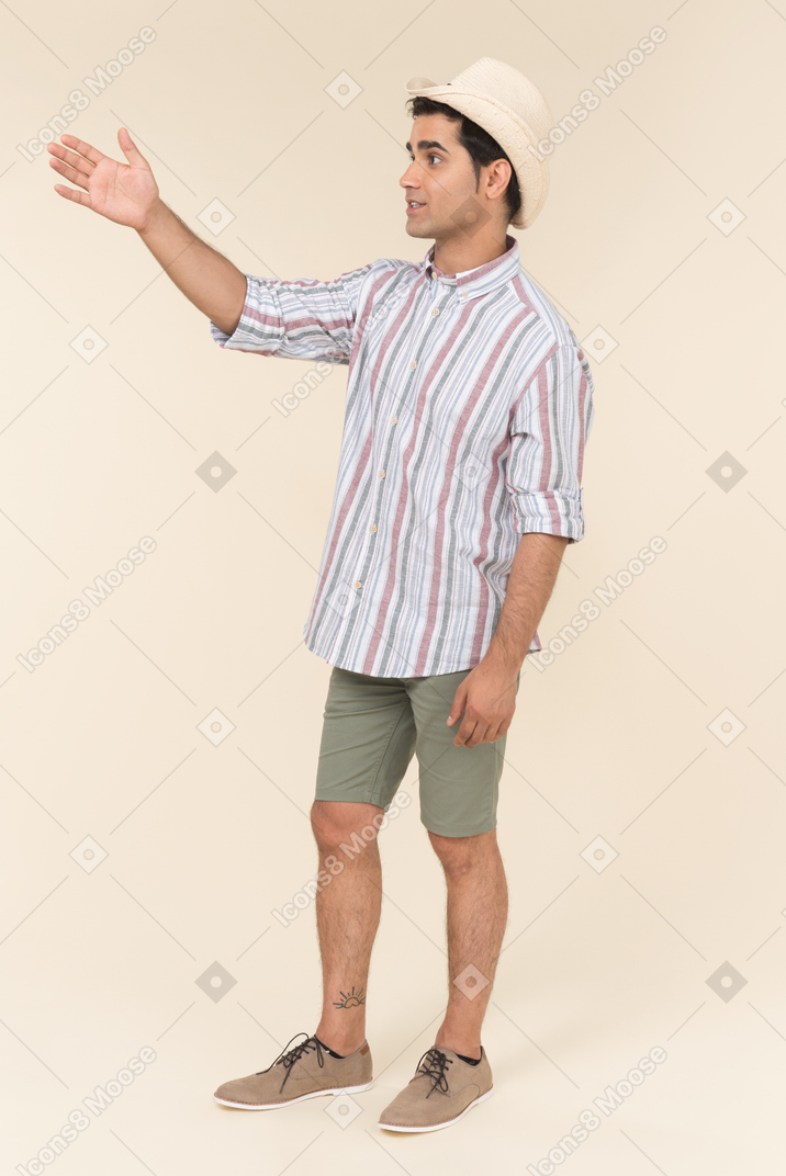 Young guy goes to the beach and greet with a hand up