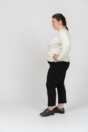 Grande taille femme en pull blanc debout avec les mains sur les hanches