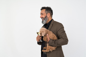 Mature man with a glass of champagne and a puppy