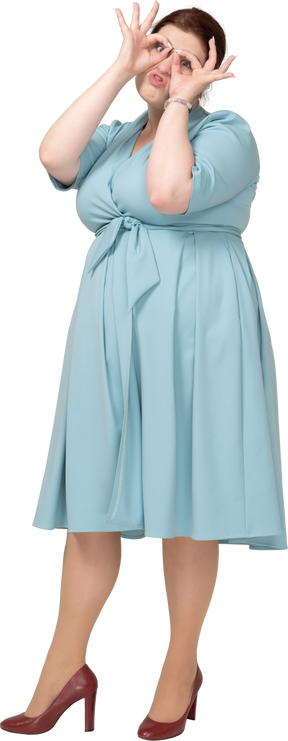 架空の双眼鏡を通して見ている青いドレスを着た女性の正面図