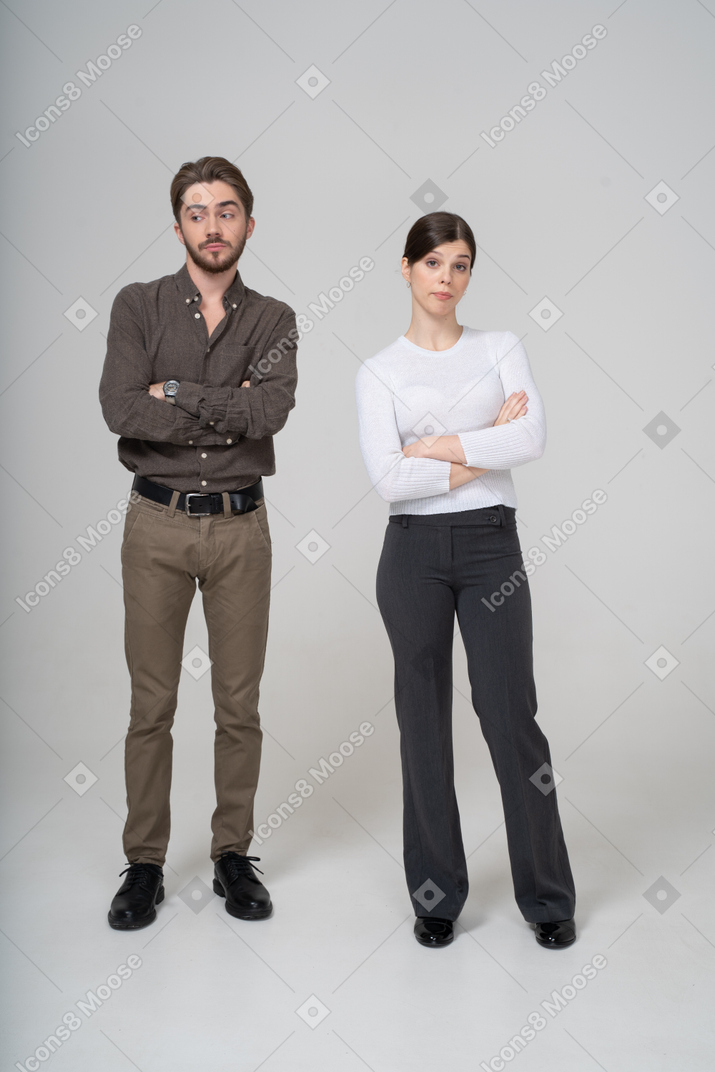 Vista frontal de um jovem casal arrogante cruzando as mãos