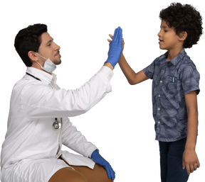 Médico dando high five para um menino