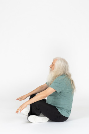 Side view of old man meditating