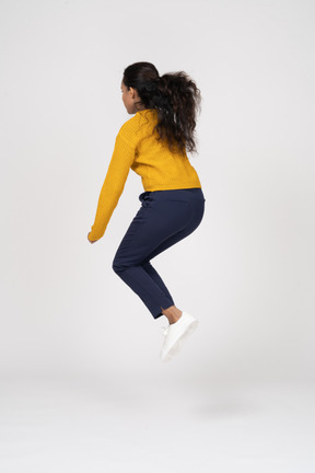 Side view of a girl in casual clothes jumping