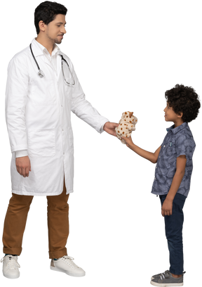 Doctor giving a toy to little kid