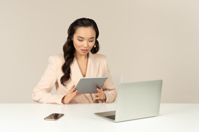 Serious asian office employee looking at tablet