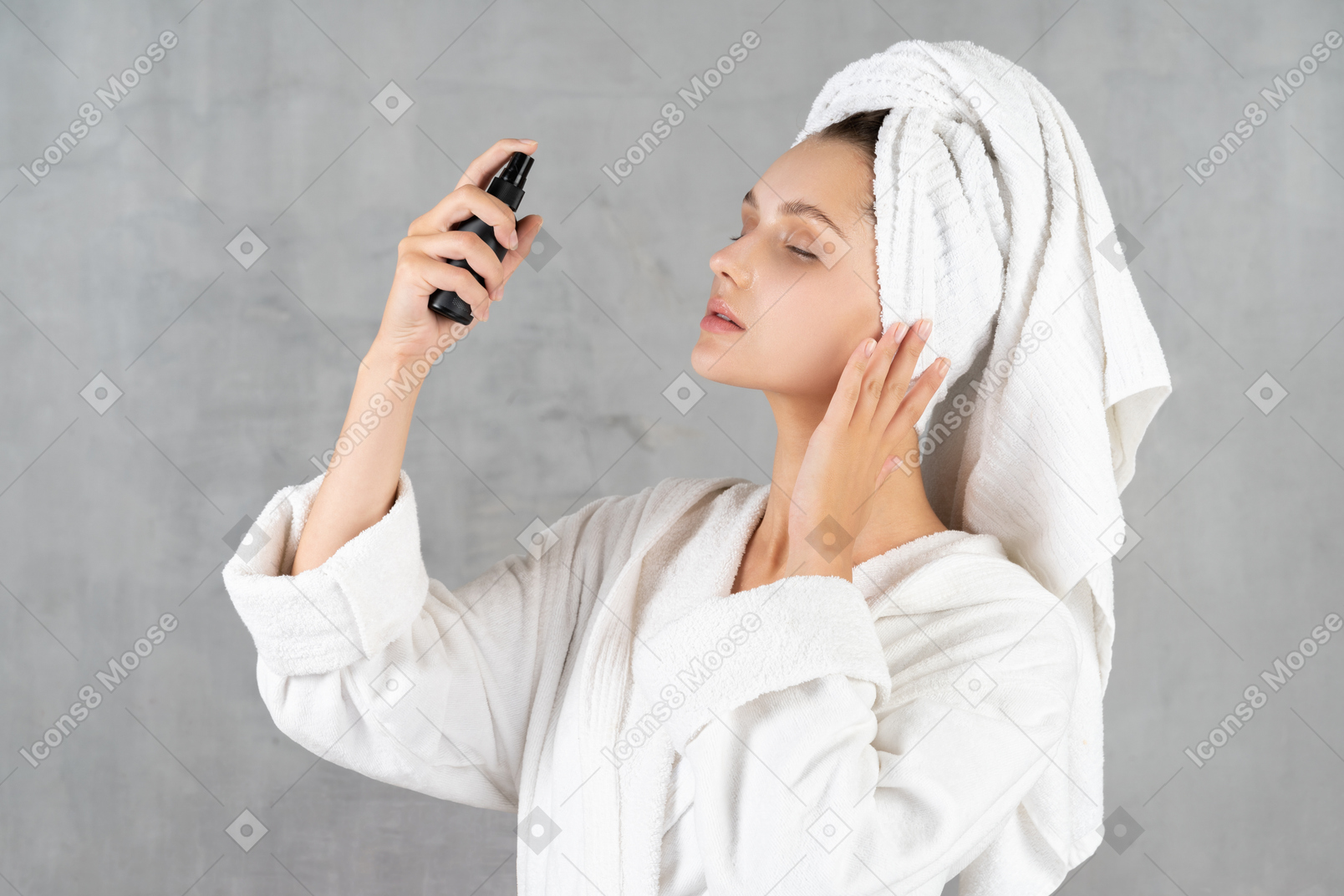 Mujer en bata de baño rociándose la cara
