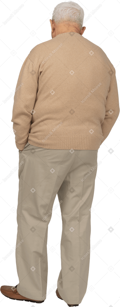 Rückansicht eines alten mannes in freizeitkleidung, der mit den händen in den taschen steht