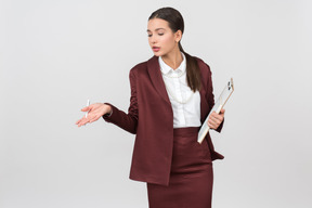 Attractive formally dressed woman with a clipboard pointing at something