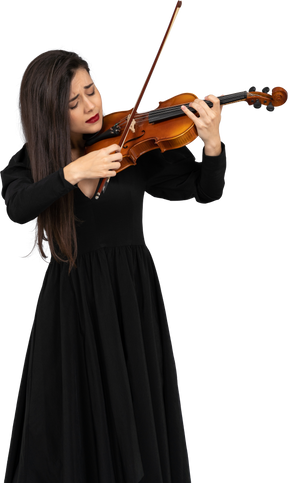 Close-up de uma jovem emocional de vestido preto tocando violino