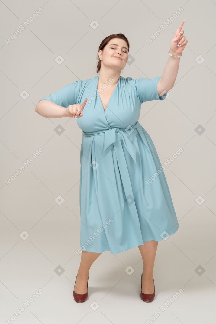 Вид спереди танцующей женщины в синем платье