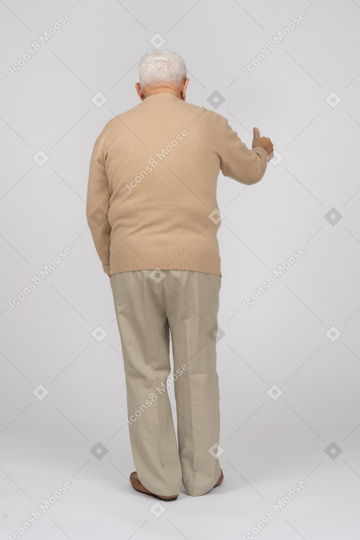 Rear view of an old man in casual clothes showing thumb up