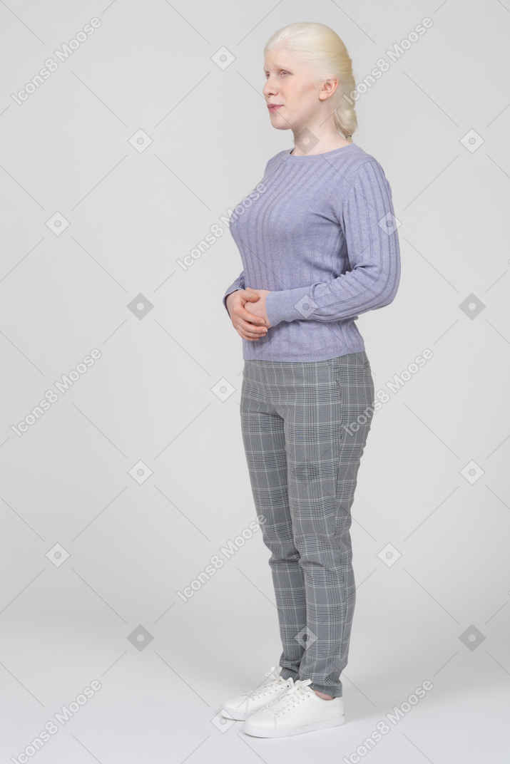 Young woman standing with hands over stomach