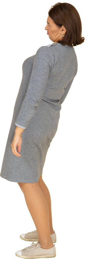 Vista laterale di una donna in abito grigio in posa
