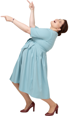 Женщина в синем платье танцует, вид сбоку