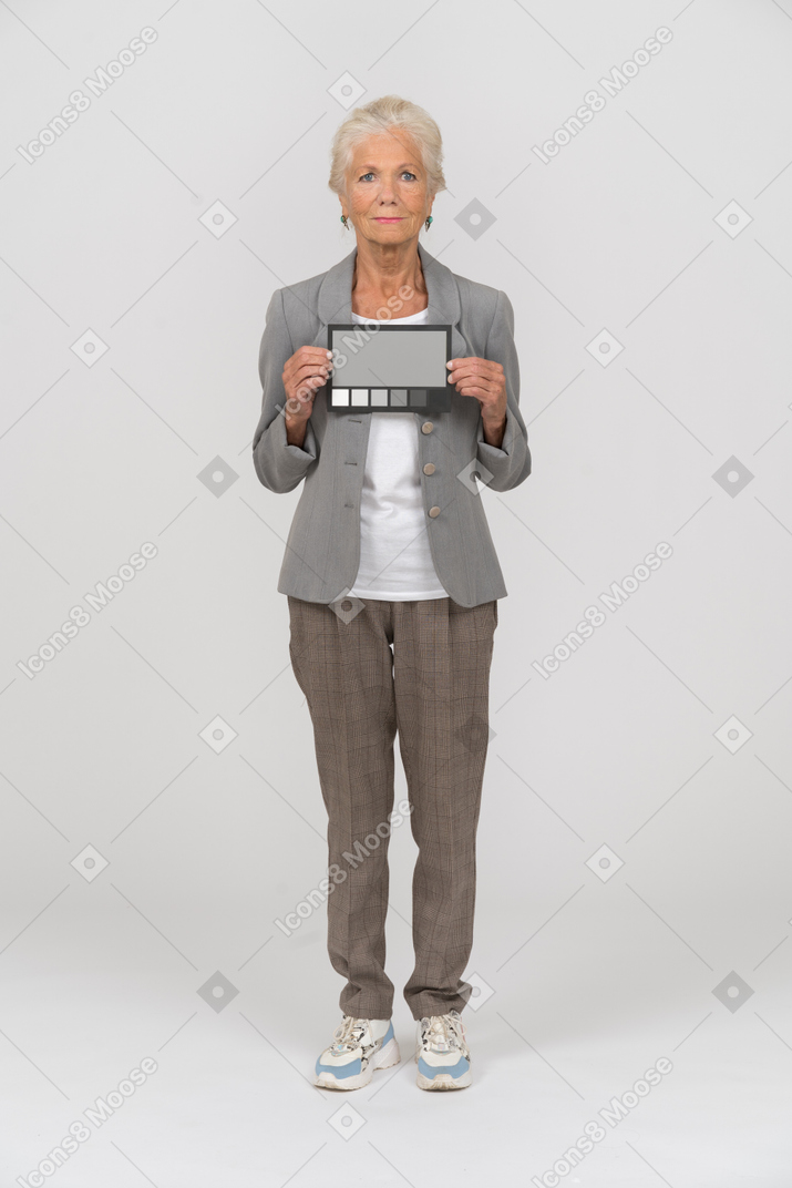 Вид спереди пожилой женщины в костюме, смотрящей в камеру